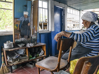 Local resident Tetiana sits on the chair inside her house damaged during the Russian occupation of Zahaltsi village near Kyiv, Ukraine, ​May...