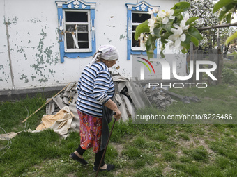 Local resident Tetiana passes near her house damaged during the Russian occupation of Zahaltsi village near Kyiv, Ukraine, ​May 13, 2022. (