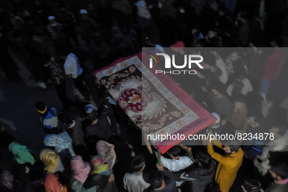 People carry the bed as they await the body of a slain civilian Shoaib Ahmad Ganai who was killed after Indian forces allegedly shot him dea...