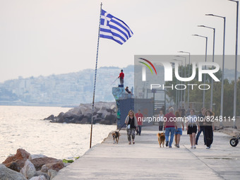 Members of the public walk along the promenade  in Athens on 17 May 2022. (