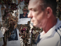 People walk past a wall of flowers with pictures of Ukrainian victims of the Russian invasion in Warsaw, Poland on 17 May, 2022. The conflic...