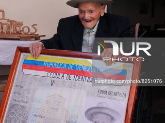 Juan Vicente Mora poses for a photograph with a portrait of his identification card. San José de Bolivar, January 24, 2022. The oldest man i...