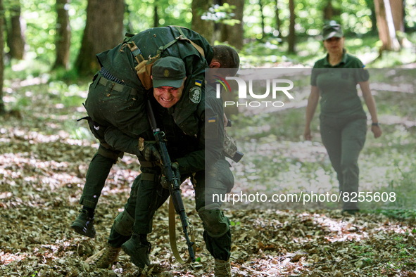 ZAKARPATTIA REGION, UKRAINE - MAY 19, 2022 - A National Guard serviceman carries his colleague during a tactical medicine exercise, Zakarpat...