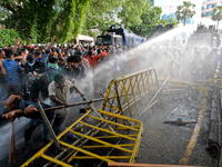Sri Lankan university student protesters react  amid water cannon splash and tear gas as the protesters clash with police against the govern...