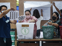 Thai electoral official counts ballot papers after voting closed in the election, Bangkok governor election at a polling station in Bangkok,...