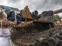 Children play and pose near destroyed Russian armored vehicles displayed for Ukrainians to see at Mykhailivska Square in downtown Kyiv, Ukra...