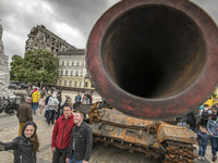 People take pictures and look at destroyed Russian armored vehicles displayed for Ukrainians to see at Mykhailivska Square in downtown Kyiv,...