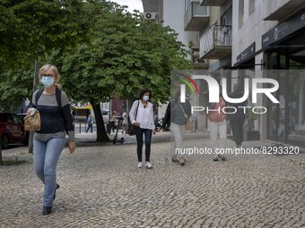 People wearing protective masks are seen walking down a downtown street. Lisbon, May 23, 2022. Portugal is the European Union country with t...