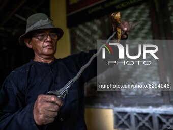 Ki Empu Sungkowo Harumbrodjo, 68, holds a Javanese Keris dagger at his workshop on May 20, 2022, in Sleman District, Yogyakarta, Indonesia....