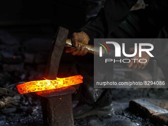 Supardi Seswowarsito, 71, hammers steel as he makes a traditional Javanese Keris daggers at his workshop on May 20, 2022, in Sleman District...