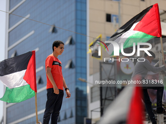 Palestinians lift national flags in Gaza City on May 29, 2022, ahead of the start of the flags march to mark Jerusalem Day, which commemorat...