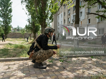 Territorial defence volunteer is seen collecting the fragment of the missile, in the area of the recent shelling where one civilian is dead...