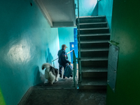 A resident of the dstroyed building is seen going downstarirs with his dog, in the area of the recent shelling where one civilian is dead an...