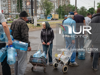 Civilians are seen queuing for the daily water distribution in one of the many spot of the city center of Mykolaiv, Ukraine, 2022-05-30. (
