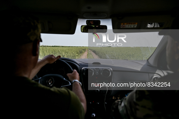 DONETSK REGION, UKRAINE - MAY 31, 2022 - Soldiers of the Armed Forces of Ukraine drive a car through the field, Donetsk Region, eastern Ukra...