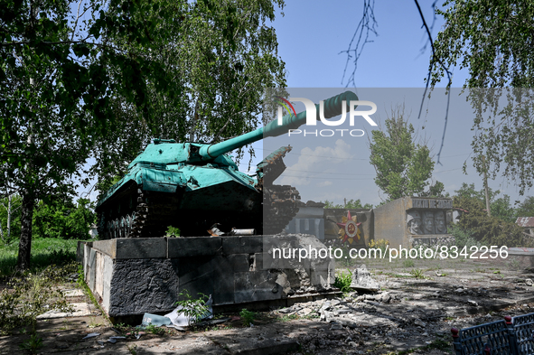 DONETSK REGION, UKRAINE - MAY 31, 2022 - An AFU soldier is seen next to a World War II tank damaged as a result of russian shelling in the v...