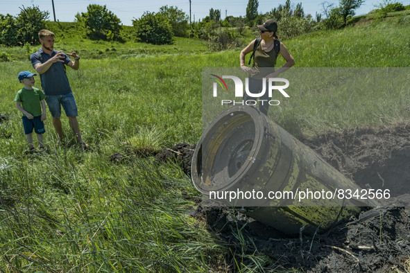 Civilians talk near the remains of a russianTochka missile intercepted by ukrainian antirocket system in the outskirts of Kostiantynivka, Do...