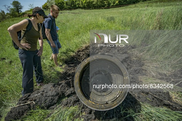 Civilians check the remains of a russian Tochka missile nailed in a field after being intercepted by ukrainian antirocket system in the outs...