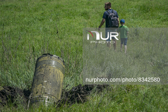 A man with his son walks throught the field in the outskirts of Kostiantynivka where a russian Tochka rocket impacted after being intercepte...