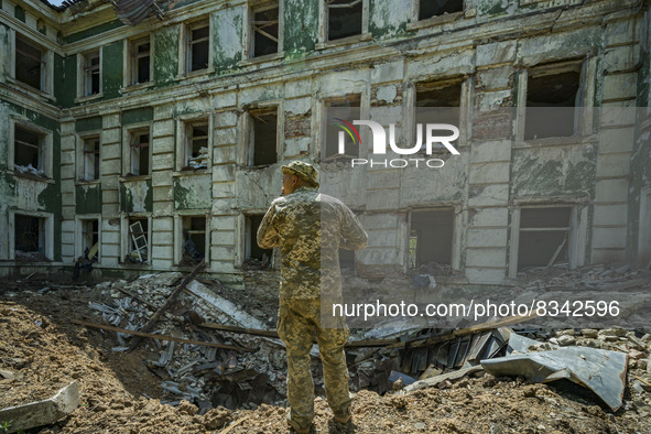 Ukrainian soldier checks the crater after the impact of a russian rocket over a high school in Kostiantynivka, Donbass. 