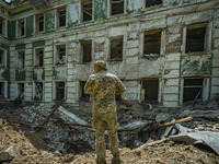 Ukrainian soldier checks the crater after the impact of a russian rocket over a high school in Kostiantynivka, Donbass. (