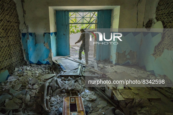 Ukrainian soldier checks the aftermath of a russian rocket impact over a high school in Kostiantynivka, Donbass. 