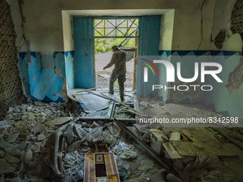 Ukrainian soldier checks the aftermath of a russian rocket impact over a high school in Kostiantynivka, Donbass. (