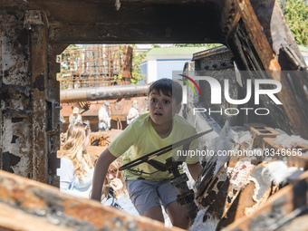 A child looks at the cabin of destroyed Russian armored Kamaz Typhoon displayed for Ukrainians to see at Mykhailivska Square in downtown Kyi...