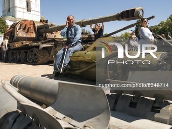A man sit on a Russian missile Tochka-U, which Russian army use in war against Ukraine, displayed for Ukrainians to see at Mykhailivska Squa...