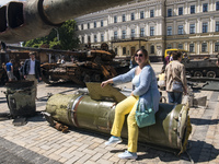 A woman poses for photography on a Russian missile Tochka-U, which Russian army use in war against Ukraine, displayed for Ukrainians to see...