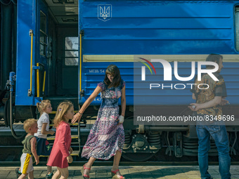 A mother with her children waits for a evacuation train for displaced people from the most destroyed villages in Donbass after the last hard...