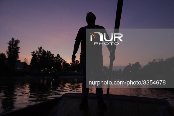 Backlighting of a paddler during sunrise on Lake Los Reyes in Tláhuac, Mexico City, where several people gathered to participate in a boat r...