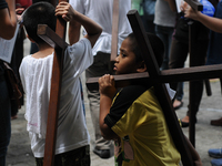 QUEZON CITY, Philippines - Filipino Catholics carry wooden crosses as they take part at the Stations of the Cross inside a chapel in Quezon...