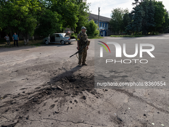 A member of the local territorial defence is seen on the location of the shelling happened during the night, in Novovorontsovka, Ukraine, 20...