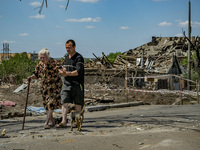 An old woman with her son leave their destroyed home after a russian airstrike over Druzhkivka city. (