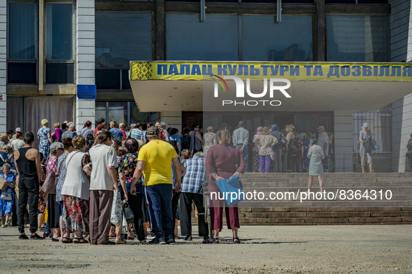 People wait in the entrance of the Culture Palace of Kostiantynivka to receive humanitarian aid. The supply of some goods was reduced drasti...