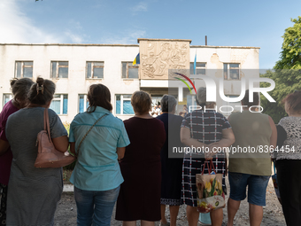 Local citizens are seen queuing to receive food, outside a former pharmacy, in Novovorontsovka, Ukraine, 2022-06-06. (