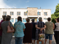 Local citizens are seen queuing to receive food, outside a former pharmacy, in Novovorontsovka, Ukraine, 2022-06-06. (