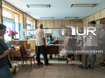 Local citizens and volunteers are seen during a disribution of food inside a former pharmacy, in Novovorontsovka, Ukraine, 2022-06-06. (