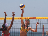 Australias’s Laird Nicole (right) knocks the ball to the Indonesia side ahead Yokebed Purari (left) during the Sepanjang Beach Volley Ball A...