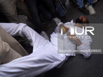 A protestor faints as he gets detained during a demonstration alleging targeted demolition drive against Muslims following clashes last week...