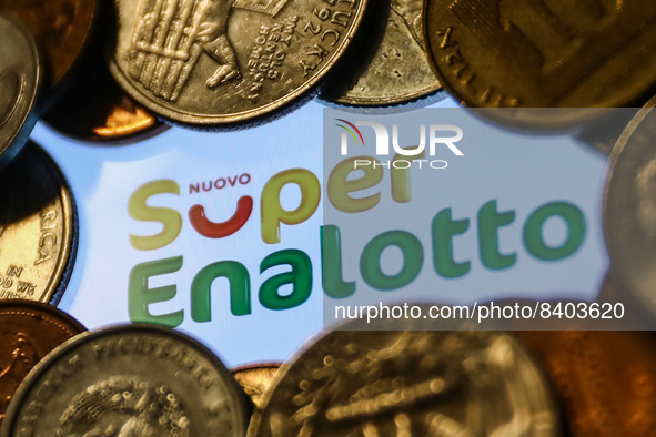 Super Enalotto logo displayed on a phone screen and coins are seen in this illustration photo taken in Krakow, Poland on June 14, 2022. (Pho...