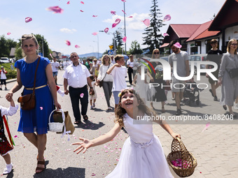 Children scatter flower petals during Corpus Christi procession in Andrychow, Poland on June 16, 2022. The procession starts with a priest c...