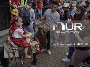 A girl rides a donkey outside the Church of the Lord of Calvary in Mexico City, on the occasion of Corpus Christi Thursday, better known as...