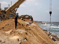 Palestinian construction workers build a seawall, from the rubble of building, to counter the coastal erosion near the al-Shati camp for Pal...