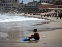 A Palestinian man sit on the shore of the Mediterranean Sea in Gaza City on June 22, 2022. (