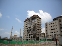 workers remove rubble of a building destroyed by an Israeli air strike during the May 2021 conflict between Israel and Hamas in Gaza City, o...