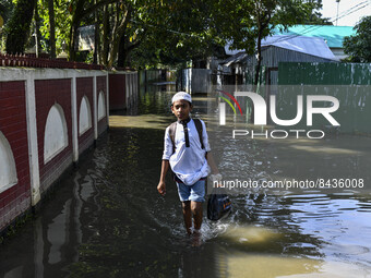 A boy wades through a flooded road after heavy rains at Sunamganj on June 22, 2022. The people of North-Eastern Bangladesh are experiencing...