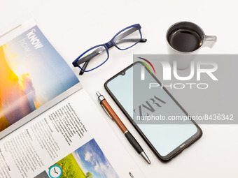 In this photo illustration a Zara logo seen displayed on a smartphone screen on a desk next to a cafe, a pen, glasses and a magazine in Athe...