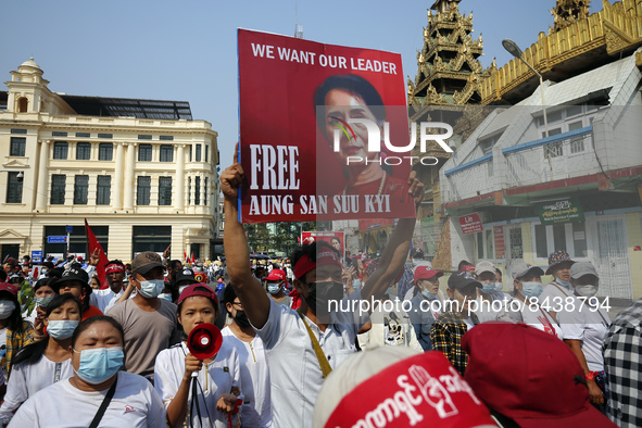 (FILE PHOTO) A protester holds a placard with a picture of Aung San Suu Kyi during a demonstration against the military coup near Sule Pagod...